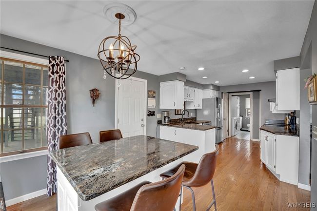 Kitchen features granite countertops, stainless steel appliances and matching counter height table/island | Image 13