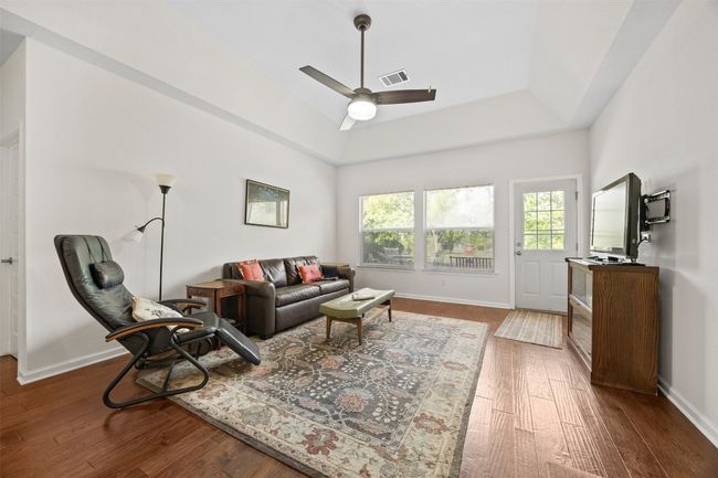 Living room with wood finished floors and a ceiling fan | Image 6