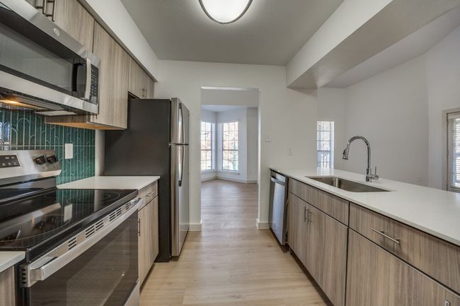 Kitchen with light hardwood / wood-style floors, sink, appliances with stainless steel finishes, and tasteful backsplash | Image 8
