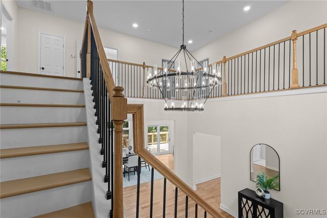Stairs featuring a chandelier, healthy amount of natural light, wood finished floors, recessed lighting, and a towering ceiling | Image 24