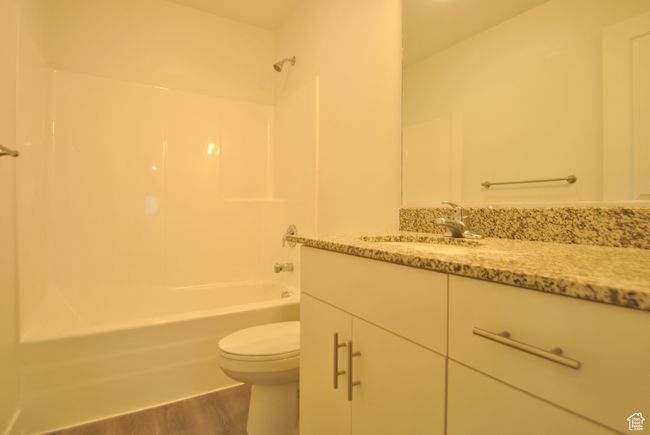 Full bath featuring vanity, shower / tub combination, and wood finished floors | Image 13