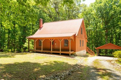 View of front facade with a front yard, covered porch, and a carport | Image 1