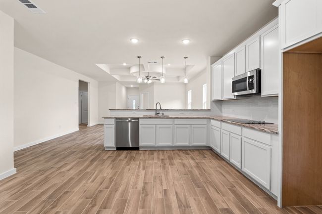 Kitchen featuring appliances with stainless steel finishes, a sink, light wood-style floors, recessed lighting, and a peninsula | Image 14