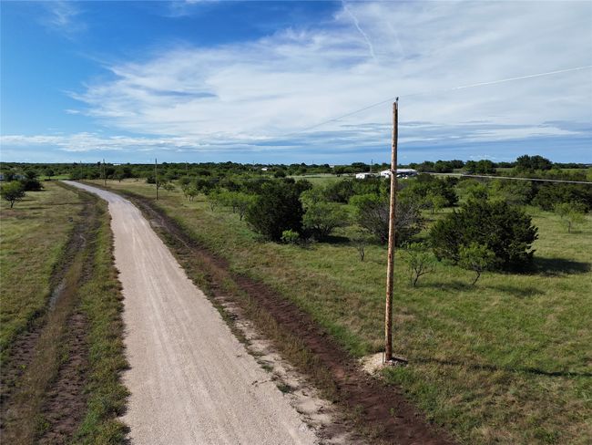 View of dirt / gravel road with a rural view | Image 12