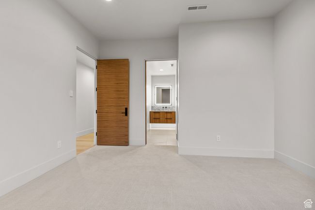 Unfurnished bedroom featuring light colored carpet, baseboards, visible vents, and recessed lighting | Image 43