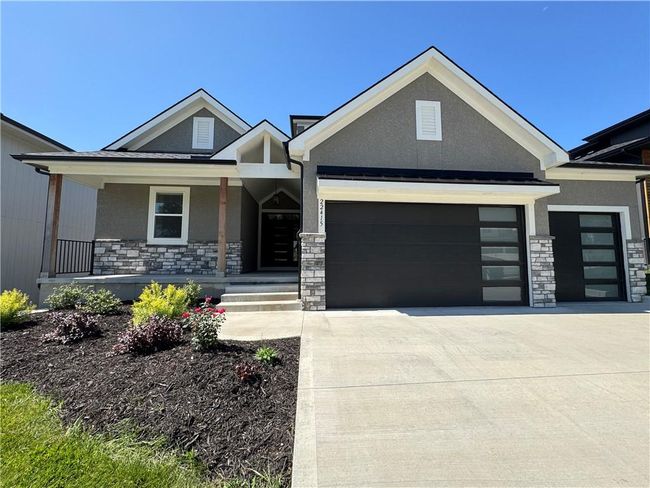 View of front facade featuring stone siding, stucco siding, and an attached garage | Image 68