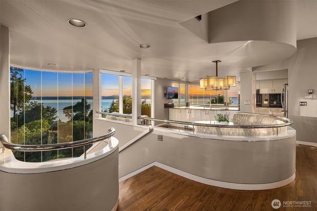 The interior curves soften the straight lines of the home; this also heightened by the choice of natural materials, finishes and colors: oak floors, metal railings, cream and dove tones... a soothing design which doesn't distract from the outdoor spectacular scenery. | Image 13