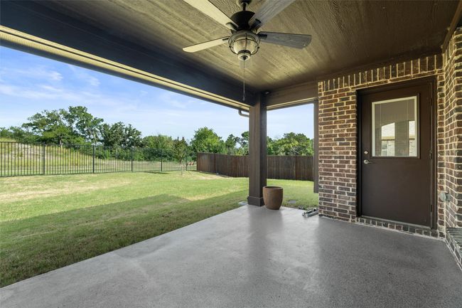 Fenced backyard with a patio area and a ceiling fan | Image 34