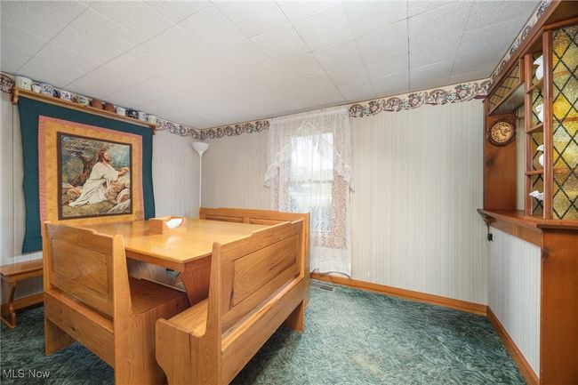Carpeted dining space with wallpapered walls and baseboards | Image 16