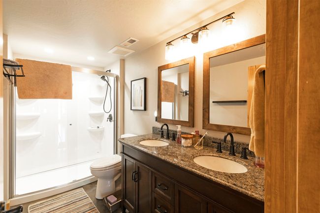 Full bathroom featuring toilet, a shower with door, and double vanity | Image 36