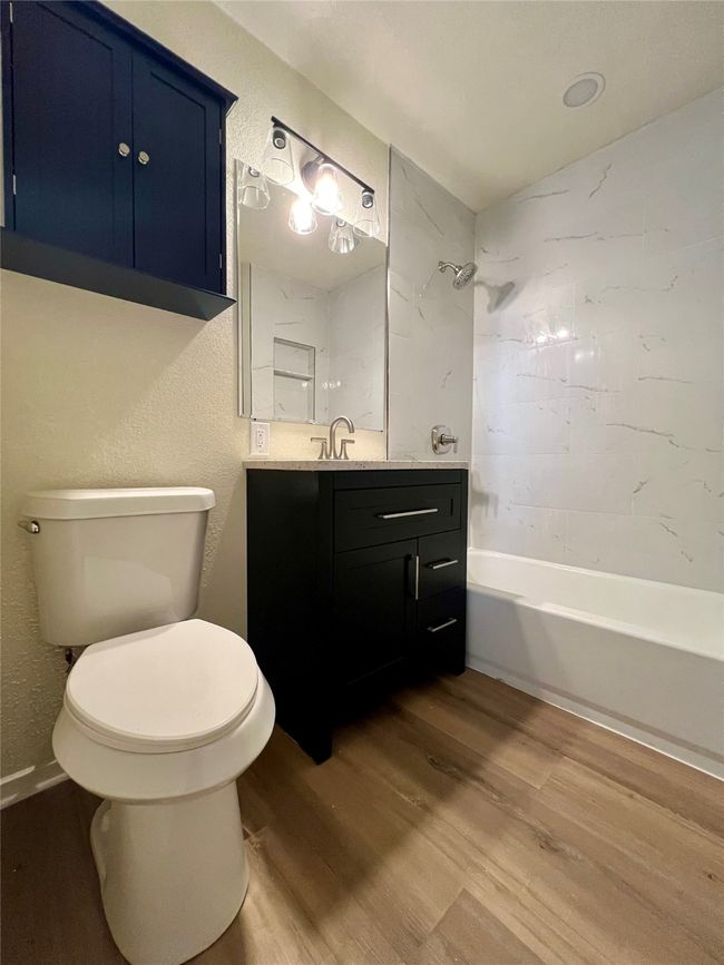 Full bathroom featuring wood finished floors, vanity, and shower / tub combination | Image 28