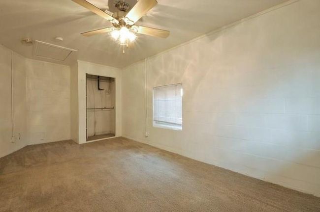 Unfurnished bedroom featuring carpet, attic access, ceiling fan, and a closet | Image 8