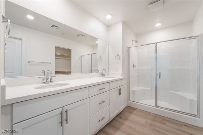 Bathroom with double vanity, a shower stall, wood finished floors, a walk in closet, and recessed lighting | Image 23