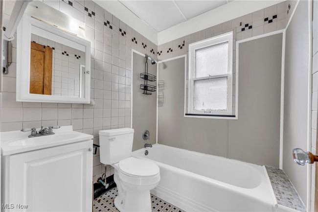 Full bath with toilet, tile walls, tub / shower combination, and vanity | Image 19