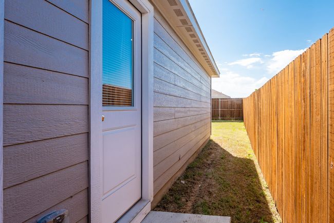 View of side of home with a yard and a fenced backyard | Image 15