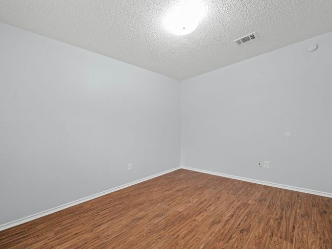 Unfurnished room with dark wood finished floors, a textured ceiling, and a smoke detector | Image 15