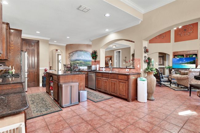 The kitchen is open to the living room, sharing the same durable tile floor. | Image 11