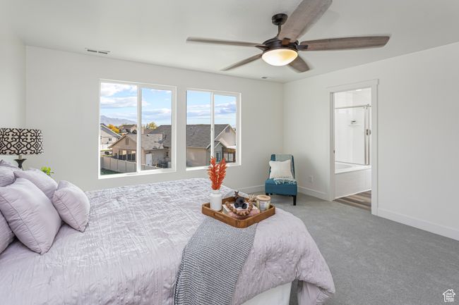 Carpeted bedroom with baseboards, visible vents, ceiling fan, and connected bathroom | Image 17
