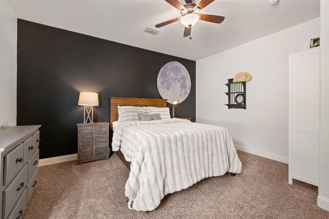 Carpeted bedroom featuring a ceiling fan, baseboards, and visible vents | Image 30