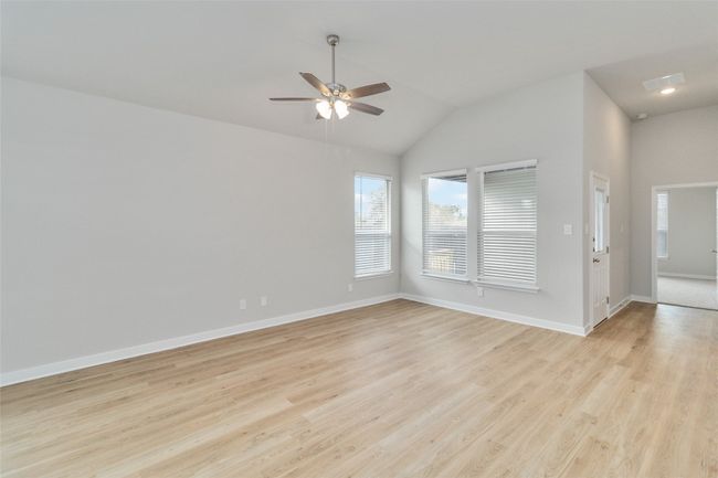 Spare room featuring visible vents, light wood-style flooring, vaulted ceiling, ceiling fan, and baseboards | Image 10