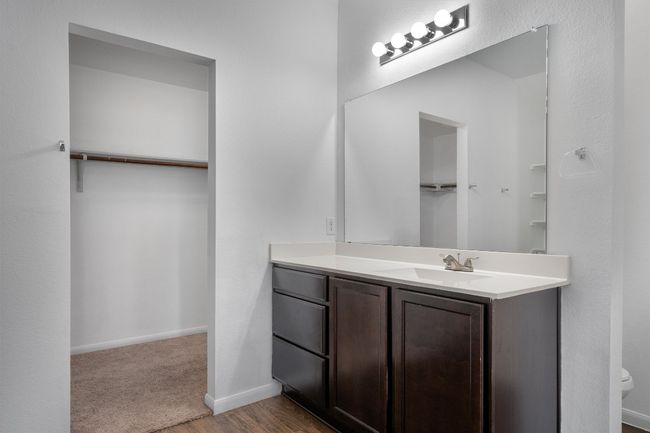 Bathroom featuring vanity, a spacious closet, toilet, and baseboards | Image 15