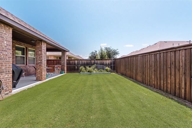 Fenced backyard with a patio | Image 35