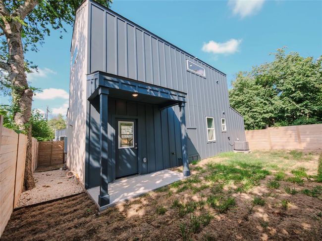 Rear view of property with board and batten siding, a fenced backyard, and a patio | Image 20