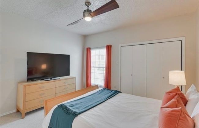 Bedroom with a textured ceiling, a closet, light carpet, and ceiling fan | Image 15