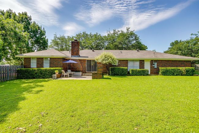 Back of house with a patio area, a chimney, and brick siding | Image 38