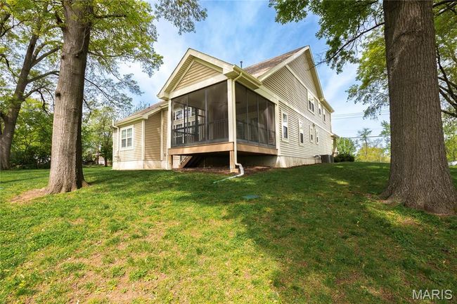 Rear view of property featuring a lawn and screened in porch | Image 44
