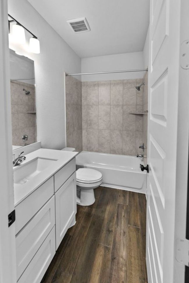 Bathroom featuring vanity, bathing tub / shower combination, and wood-type flooring | Image 22