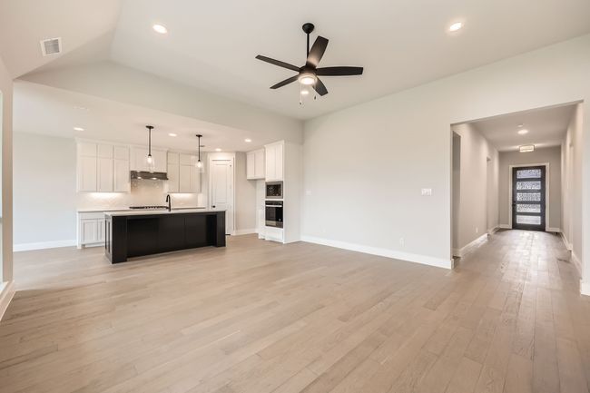 Kitchen featuring visible vents, stainless steel appliances, a ceiling fan, and open floor plan | Image 5