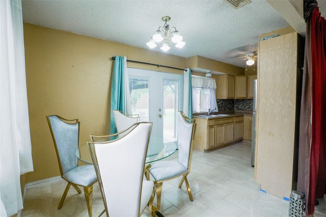 Dining space with a textured ceiling, a chandelier, french doors, and a ceiling fan | Image 4