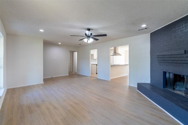 Unfurnished living room featuring a ceiling fan, a textured ceiling, visible vents, and light wood-type flooring | Image 26