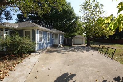 View of home's exterior with a garage, a lawn, and an outbuilding | Image 2