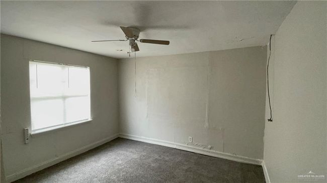 Spare room featuring a ceiling fan, carpet floors, and baseboards | Image 12