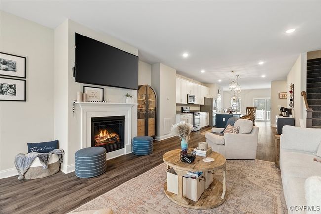 Living room featuring wood-type flooring and a notable chandelier | Image 5