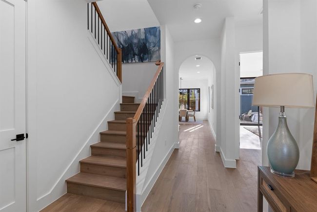 Staircase with arched walkways, wood finished floors, and recessed lighting | Image 7