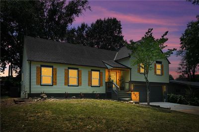 View of front of property with central AC unit, a garage, and a yard | Image 1