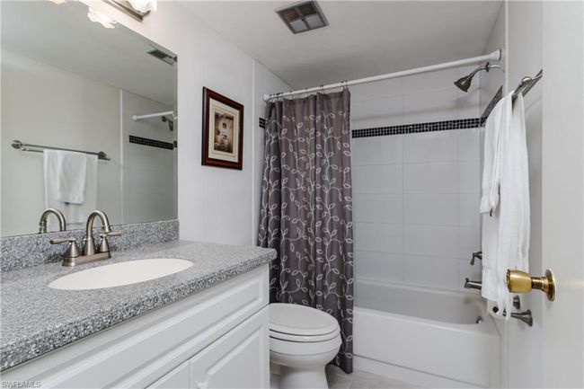 Full bathroom with tile patterned floors, visible vents, toilet, vanity, and shower / tub combo | Image 21