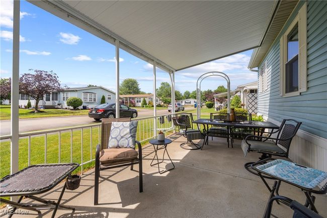 Sunroom with a residential view and outdoor dining area | Image 6