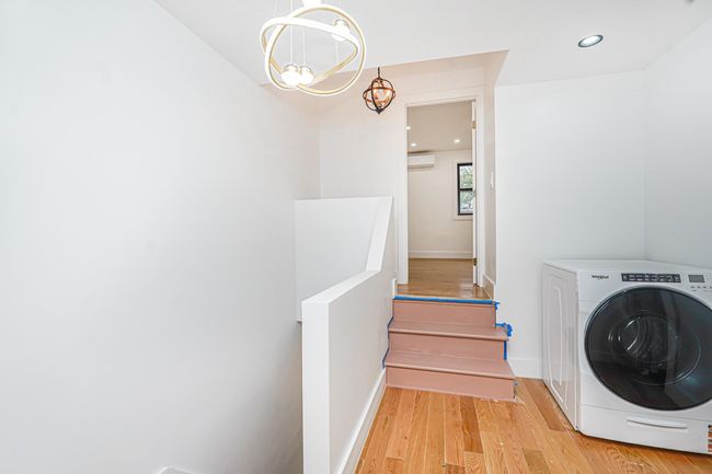 Laundry room with washer / dryer, wood finished floors, a chandelier, recessed lighting, and a wall unit AC | Image 5