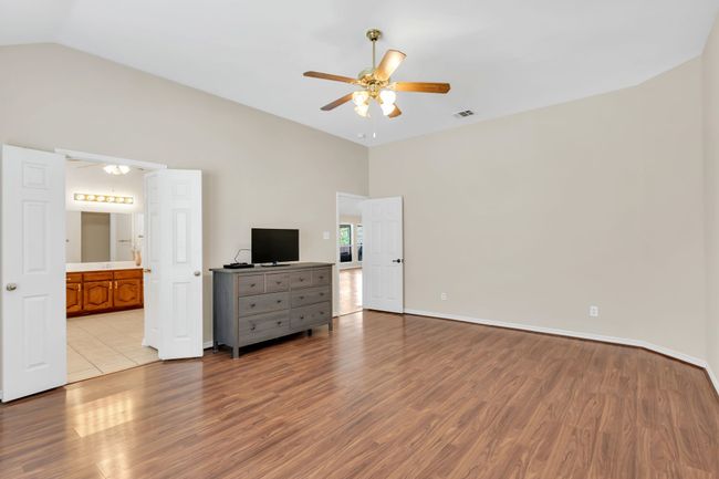 Primary bedroom featuring high vaulted ceiling, wood finished floors, ensuite bathroom | Image 21