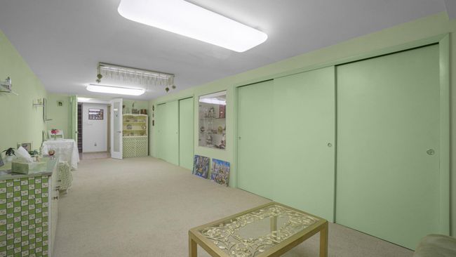 Kitchen featuring a sink, freestanding refrigerator, black microwave, baseboard heating, and tile walls | Image 22