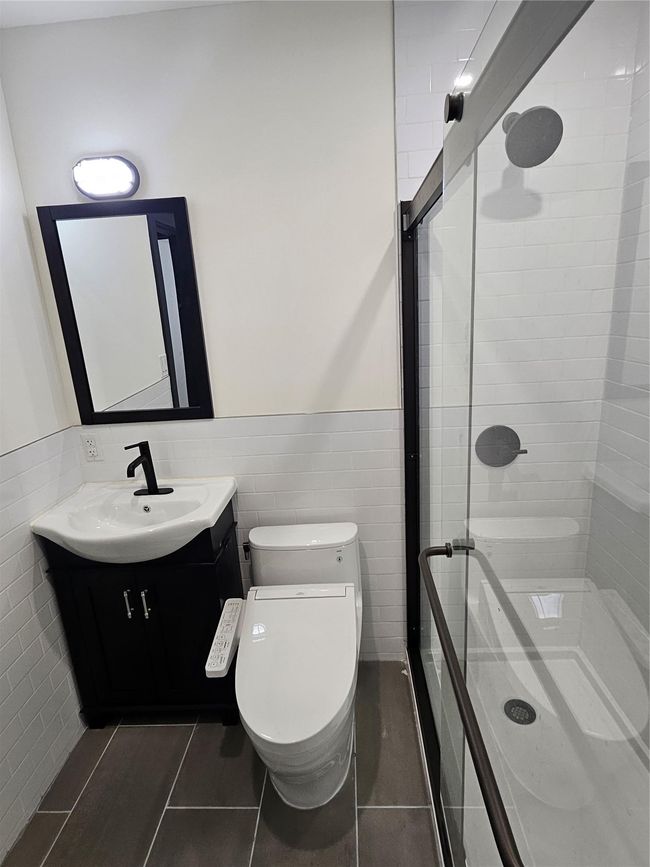 Bathroom featuring vanity, a stall shower, toilet, tile patterned floors, and wainscoting | Image 23