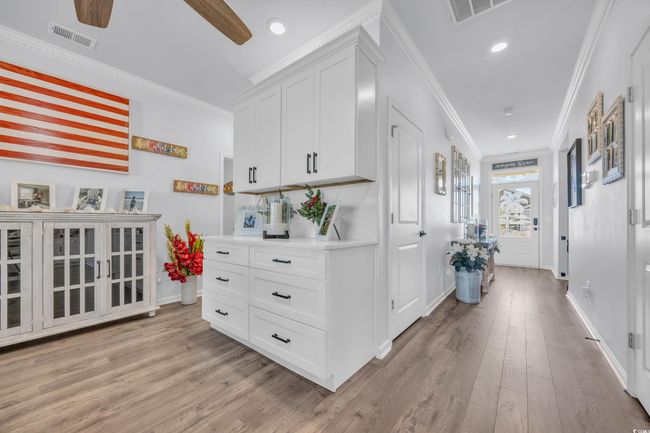 Hallway with ornamental molding, light wood-type flooring, baseboards, and recessed lighting | Image 13