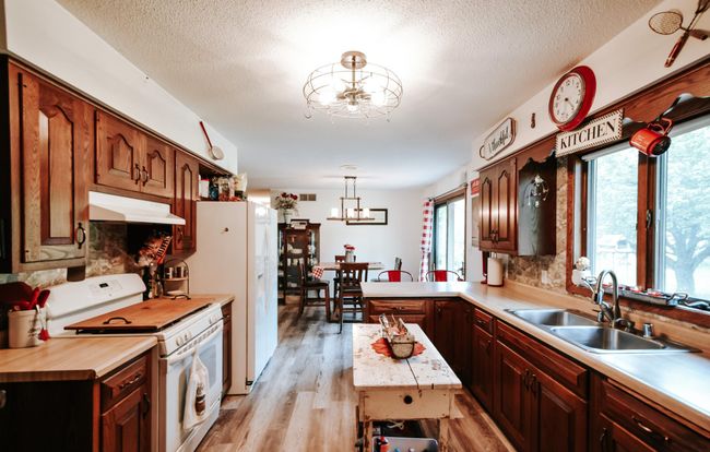 New flooring, updated light, lots of storage behind those 2 wooden doors, natural light with the mudroom door and the laundry room window. Lower wood cabinet to the right DOES NOT stay- it is removable and sellers antique. Upper shelves stay. | Image 11