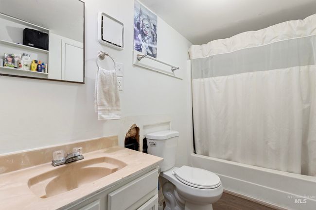 Bathroom with vanity, shower / tub combo with curtain, and wood finished floors | Image 16