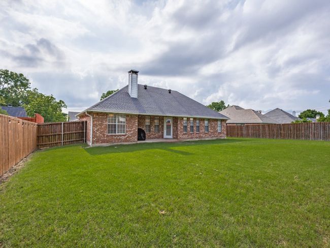 Back of property featuring brick siding, a chimney, and a shingled roof | Image 25