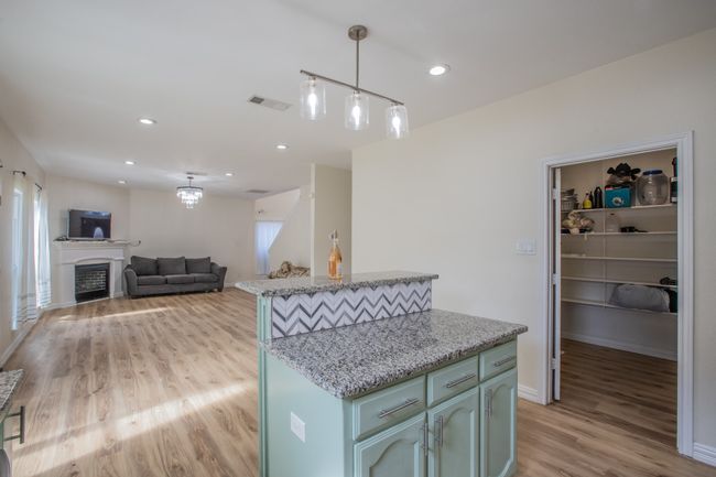 Kitchen featuring baseboards, pendant lighting, visible vents, and light wood-type flooring | Image 6